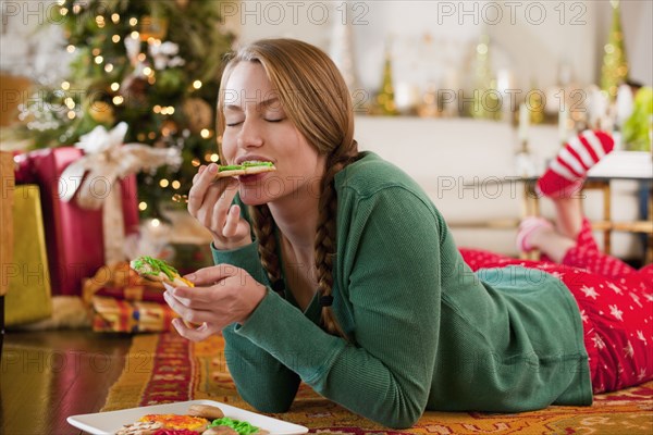 Caucasian woman eating Christmas cookies