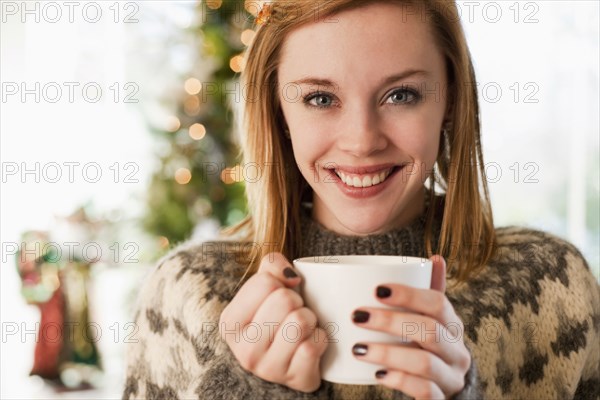 Caucasian woman drinking coffee at Christmas