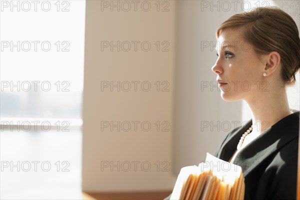 Caucasian businesswoman holding files