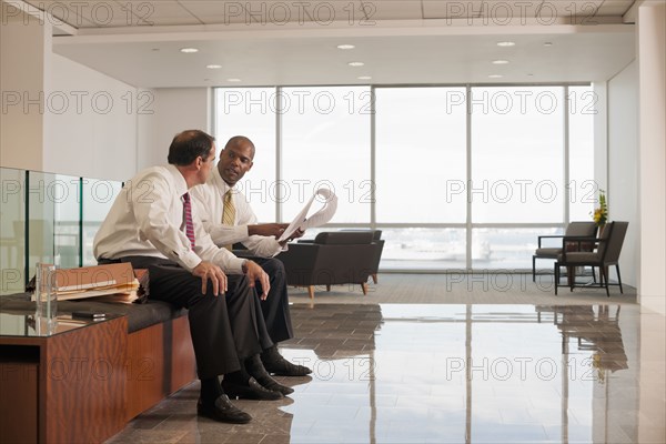 Businessmen reviewing paperwork together