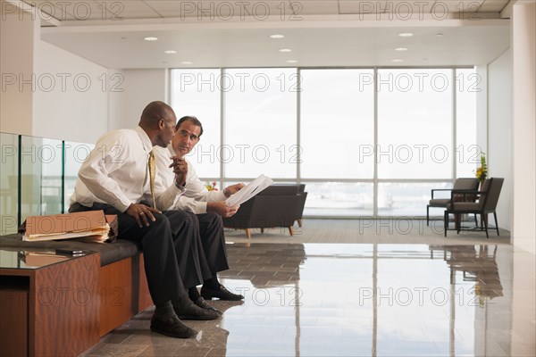 Businessmen reviewing paperwork together