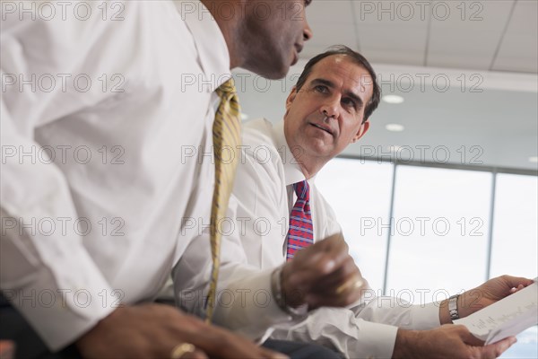 Businessmen reviewing paperwork together