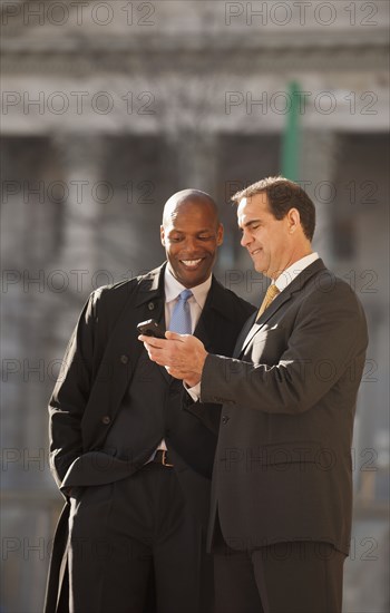 Businessmen looking at cell phone
