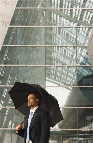 Caucasian businessman underneath umbrella