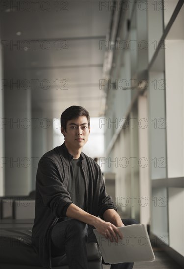 Mixed race businessman holding papers