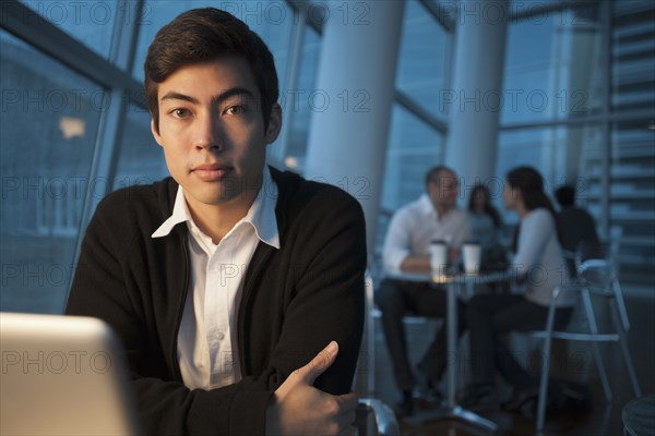 Mixed race businessman using laptop in cafe