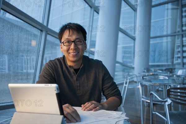 Asian businessman working with digital tablet in cafe