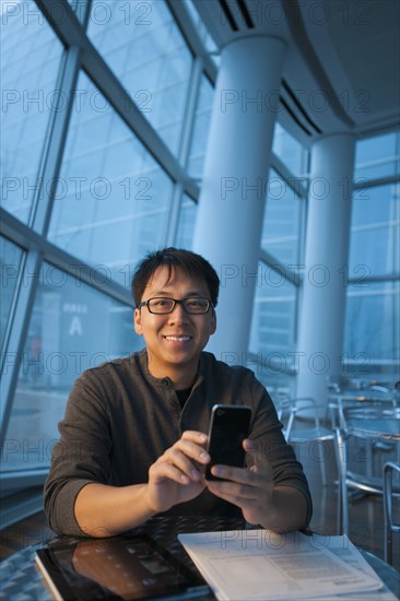 Asian businessman text messaging on cell phone