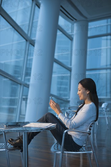 Asian businesswoman text messaging on cell phone