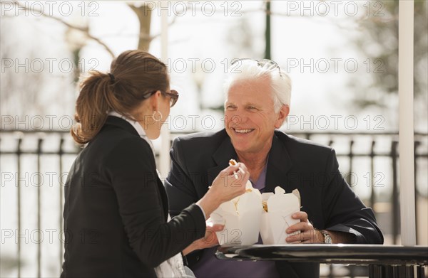 Caucasian business people eating Asian food