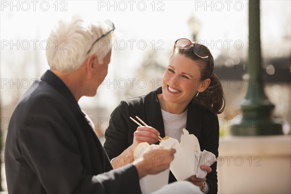 Caucasian business people eating Asian food