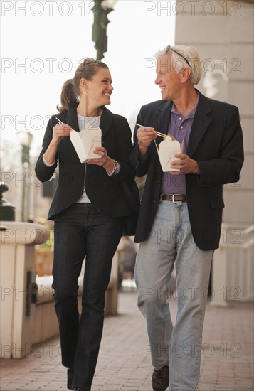 Caucasian business people eating Asian food