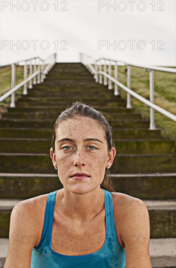 Serious Caucasian woman sitting on steps