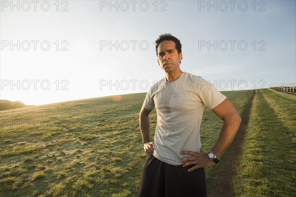 Mixed race runner standing in field