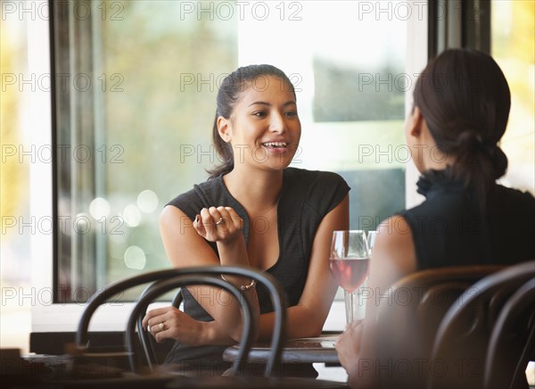 Asian friends sitting together in cafe