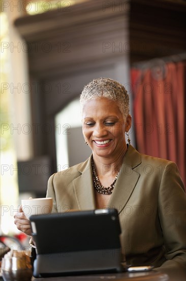 African American businesswoman using digital tablet in cafe
