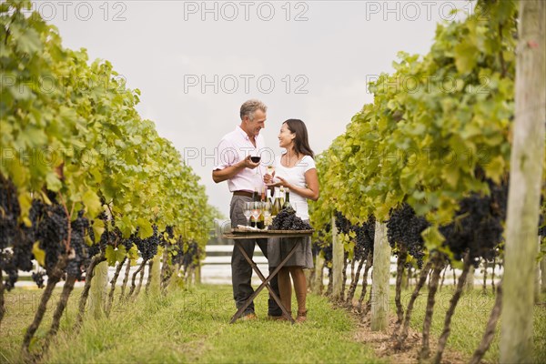 Couple tasting wine together in vineyard