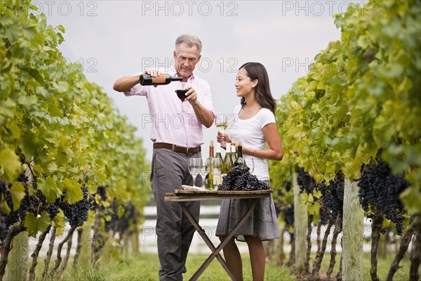 Couple tasting wine together in vineyard