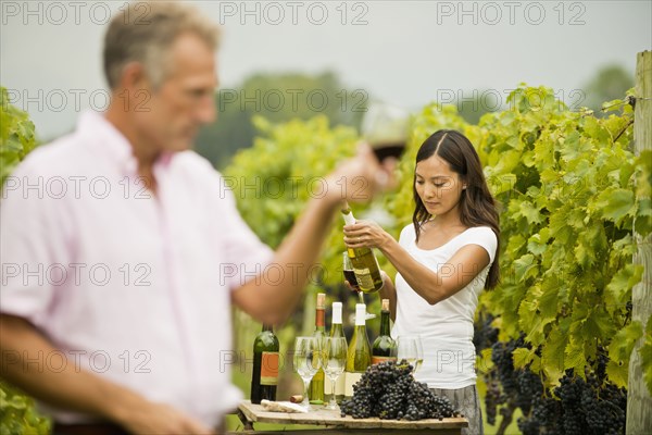 People tasting wine in vineyard