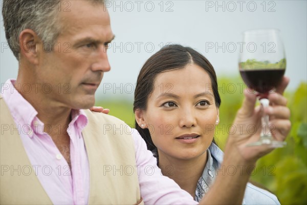 Couple tasting wine together in vineyard