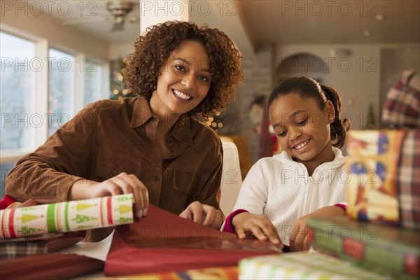 Mother and daughter wrapping Christmas presents