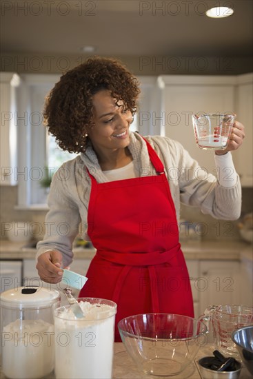 Mixed race woman baking in kitchen