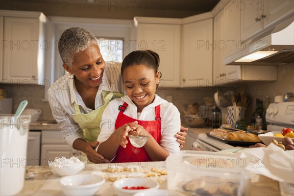 Woman and granddaughter baking in kitchen