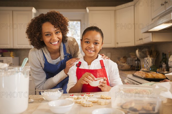 Mother and daughter baking in kitchen