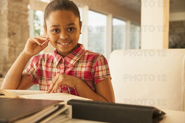 African American girl reading at table