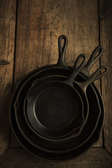 Empty cast iron pans on wooden board