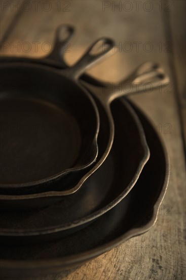 Empty cast iron pans on wooden board