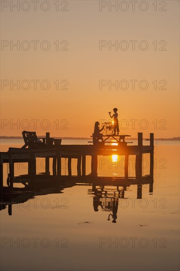 Silhouette of Caucasian children on wooden dock