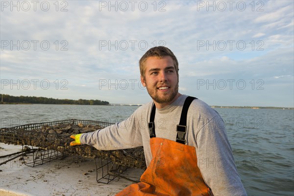 Caucasian fisherman holding net on boat