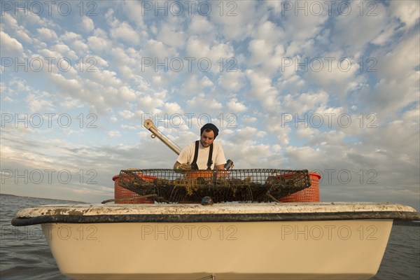 Caucasian fisherman examining net on boat