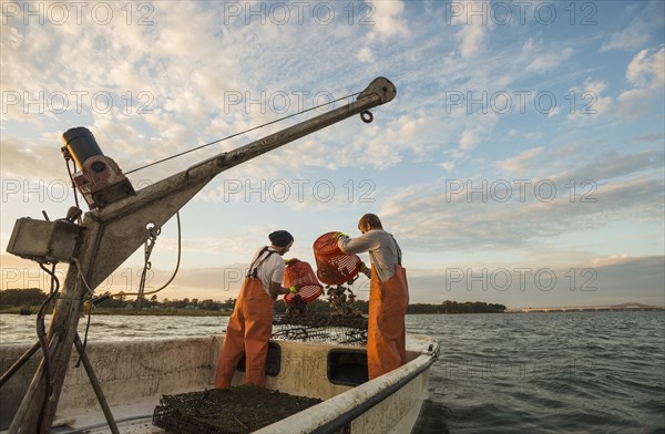 Caucasian fishermen throwing bait into water