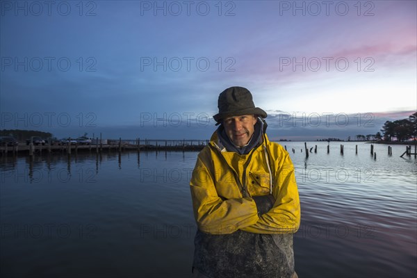 Caucasian fisherman standing by ocean