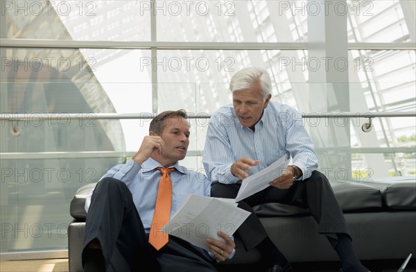 Caucasian businessmen talking in lobby area