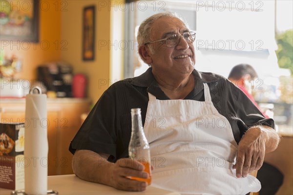 Hispanic chef drinking soda in cafe