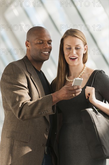 Business people using cell phone in lobby