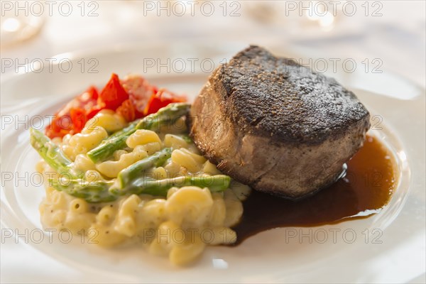 Plate of seared meat with vegetables and pasta