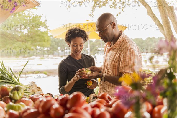 African American couple browsing produce in farmers market