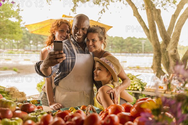 Family taking cell phone selfie at farmers market