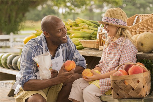 Vendor talking to girl at farmers market