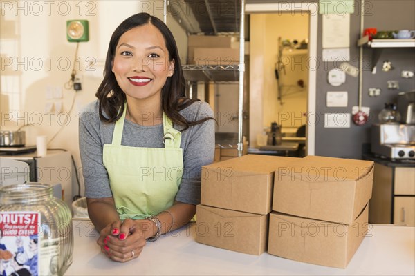 Asian baker smiling in bakery