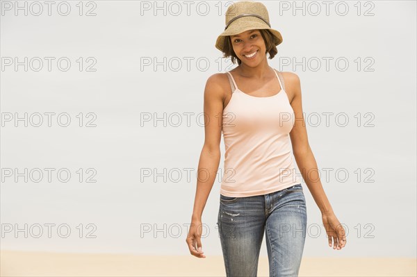 African American woman walking on beach