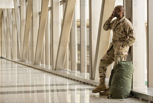 African American soldier talking on cell phone in airport