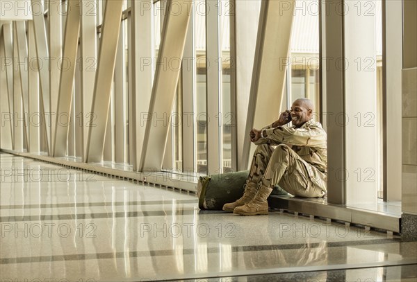 African American soldier talking on cell phone in airport