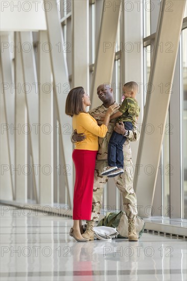 African American soldier greeting family in airport