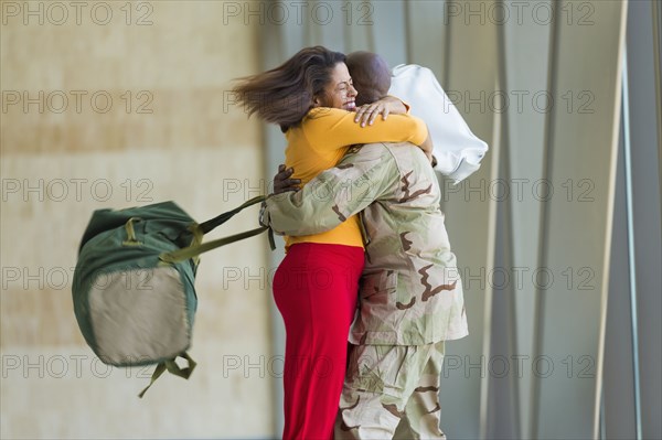 African American soldier hugging wife in airport