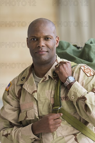 African American soldier carrying duffel bag